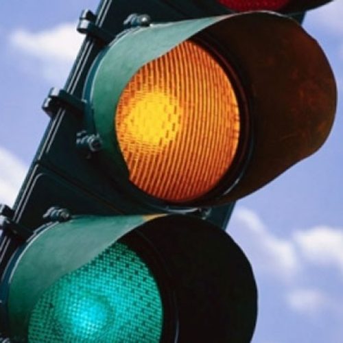 Acidente entre carro e moto em cruzamento com semáforo